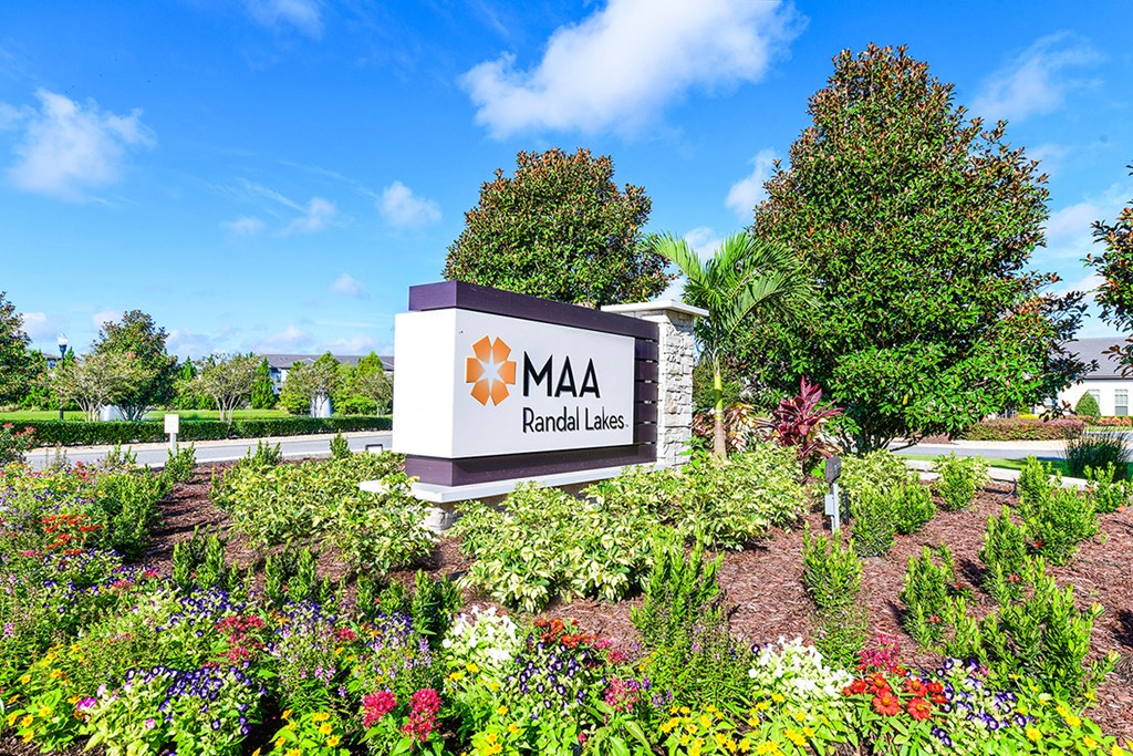 a sign in front of a garden with flowers