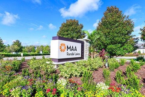 a sign in front of a garden with flowers