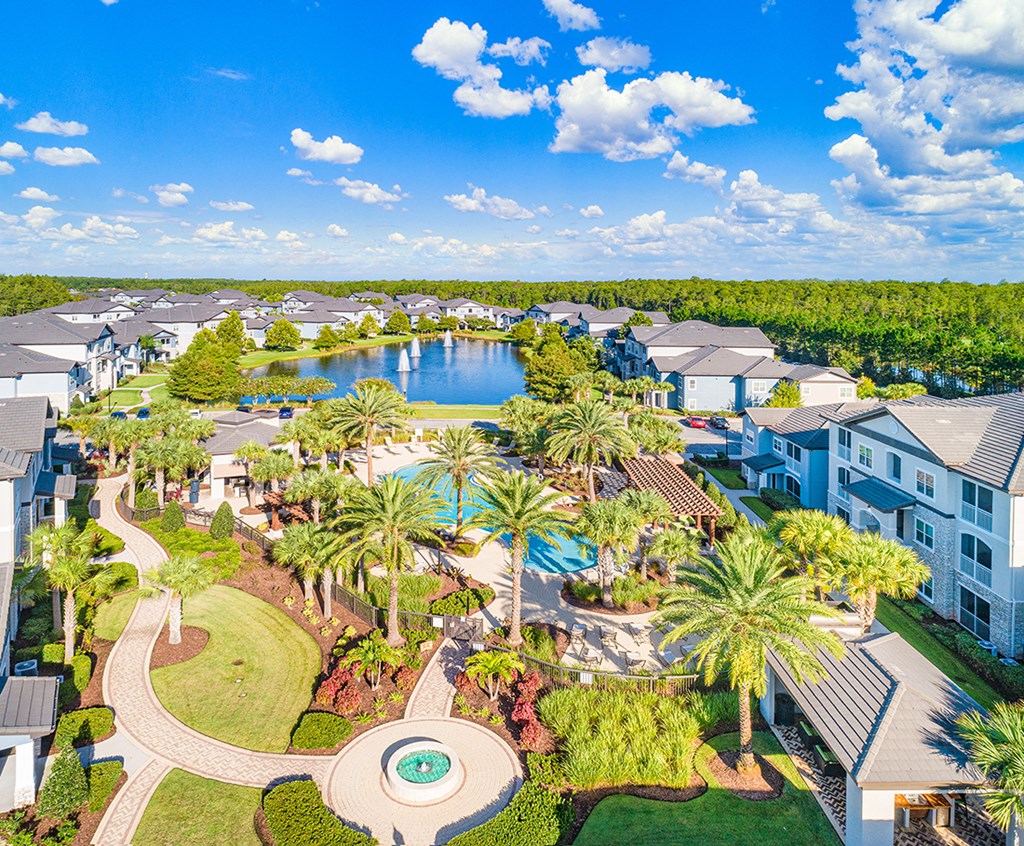 an aerial view of the resort with a pool and a lake