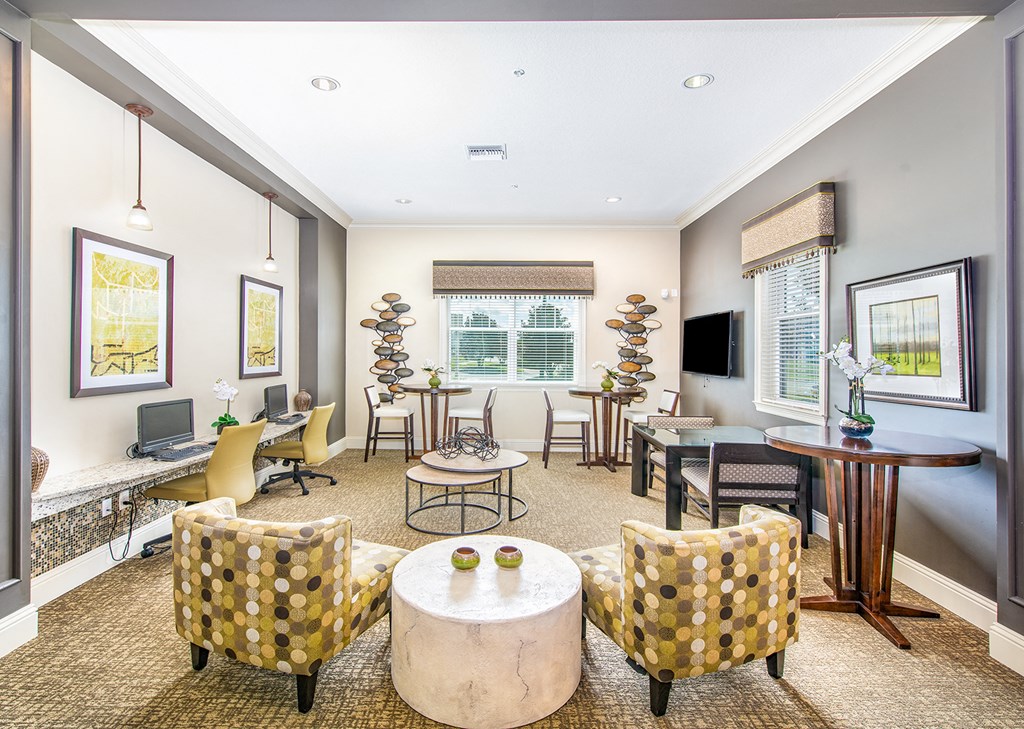 a living room with chairs and tables and a television