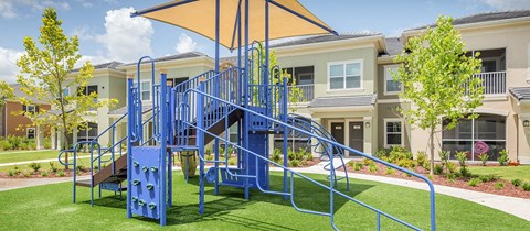 a blue playground in front of an apartment building