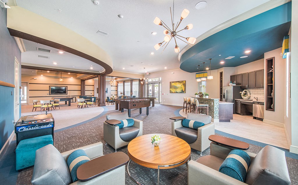 a clubhouse with couches tables and chairs and a pool table