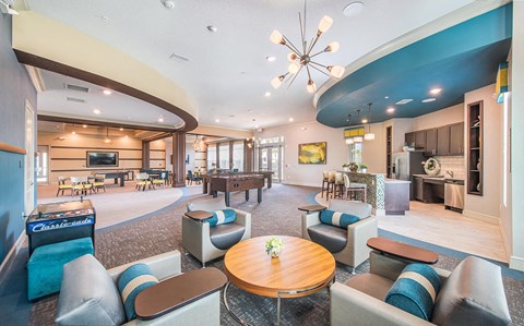 a clubhouse with couches tables and chairs and a pool table