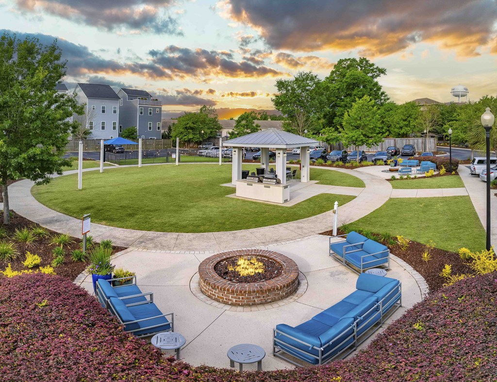 an aerial view of a park with a fire pit and benches