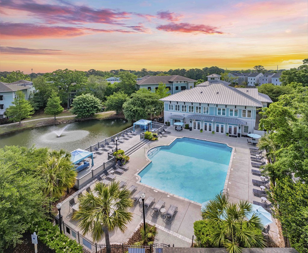 an aerial view of a swimming pool with a building in the background