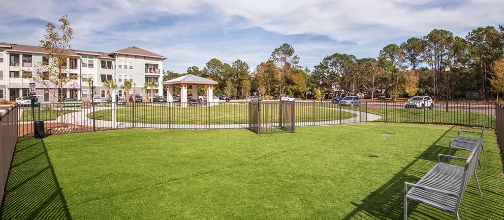 a yard with a fence around it and a building in the background