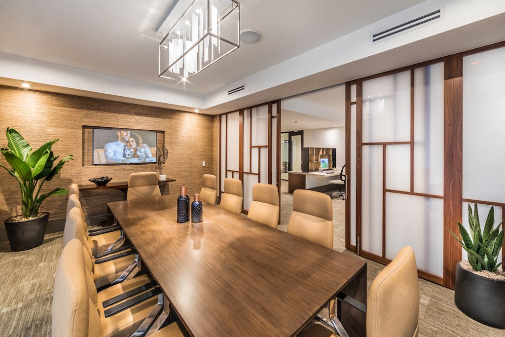 a conference room with a wooden table and chairs and a tv on the wall