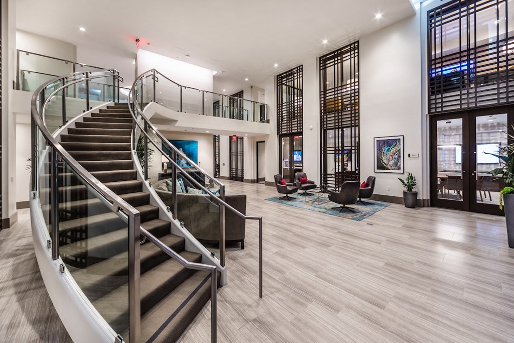 a large lobby with a staircase and a glass spiral staircase