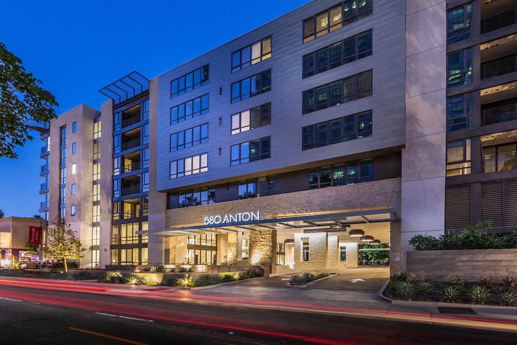 an exterior view of a building at night with a street in front