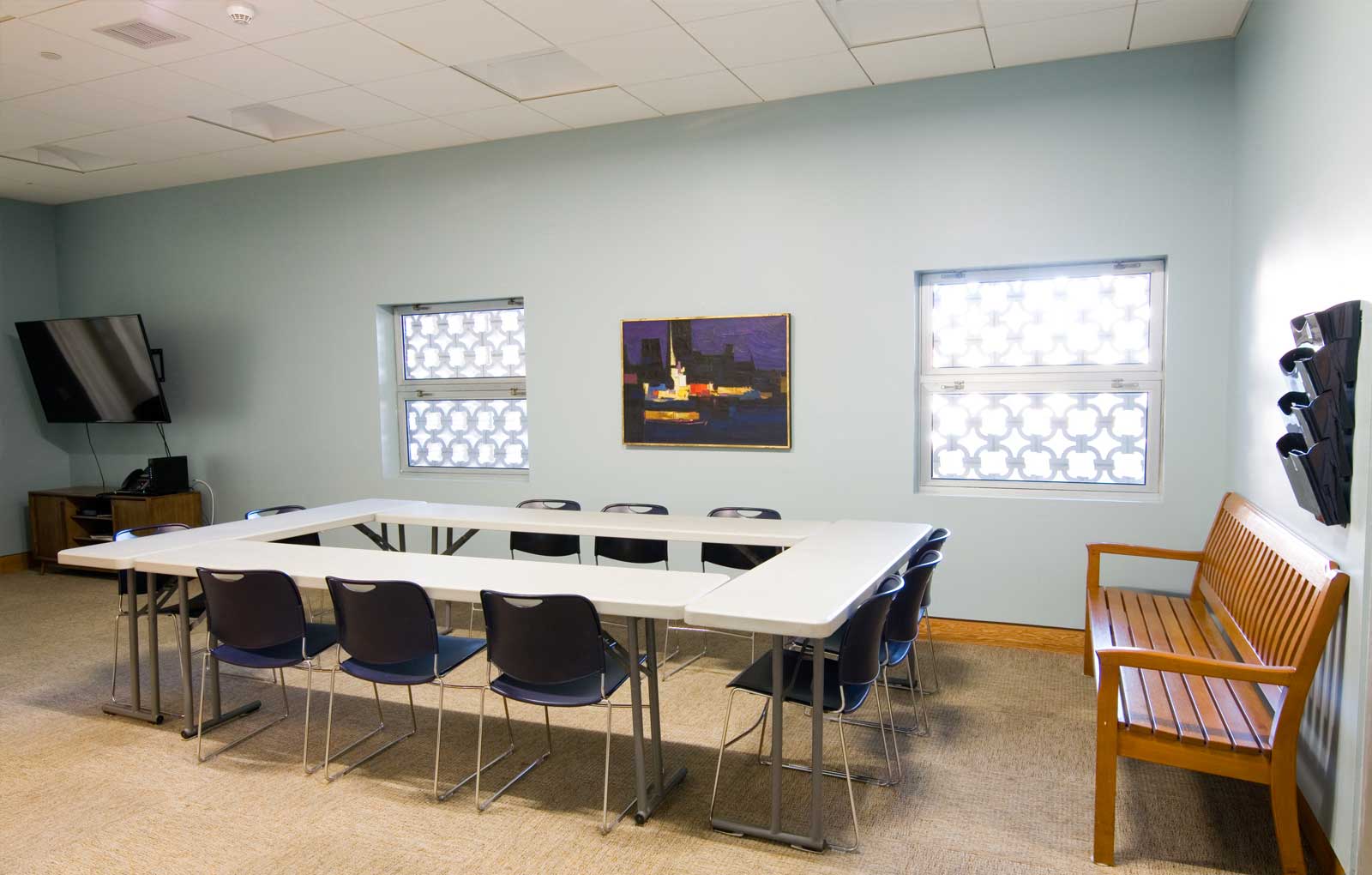 Community room with windows, large table, plentiful seating, and more.