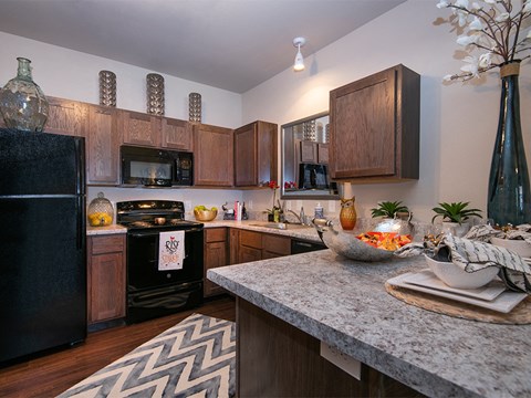 a kitchen with a granite counter top and a black refrigerator