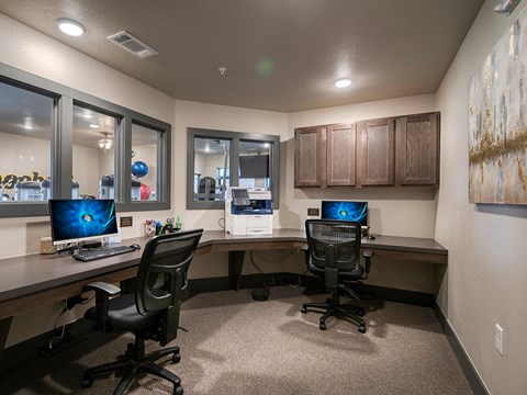 an office with two desks and two computer monitors