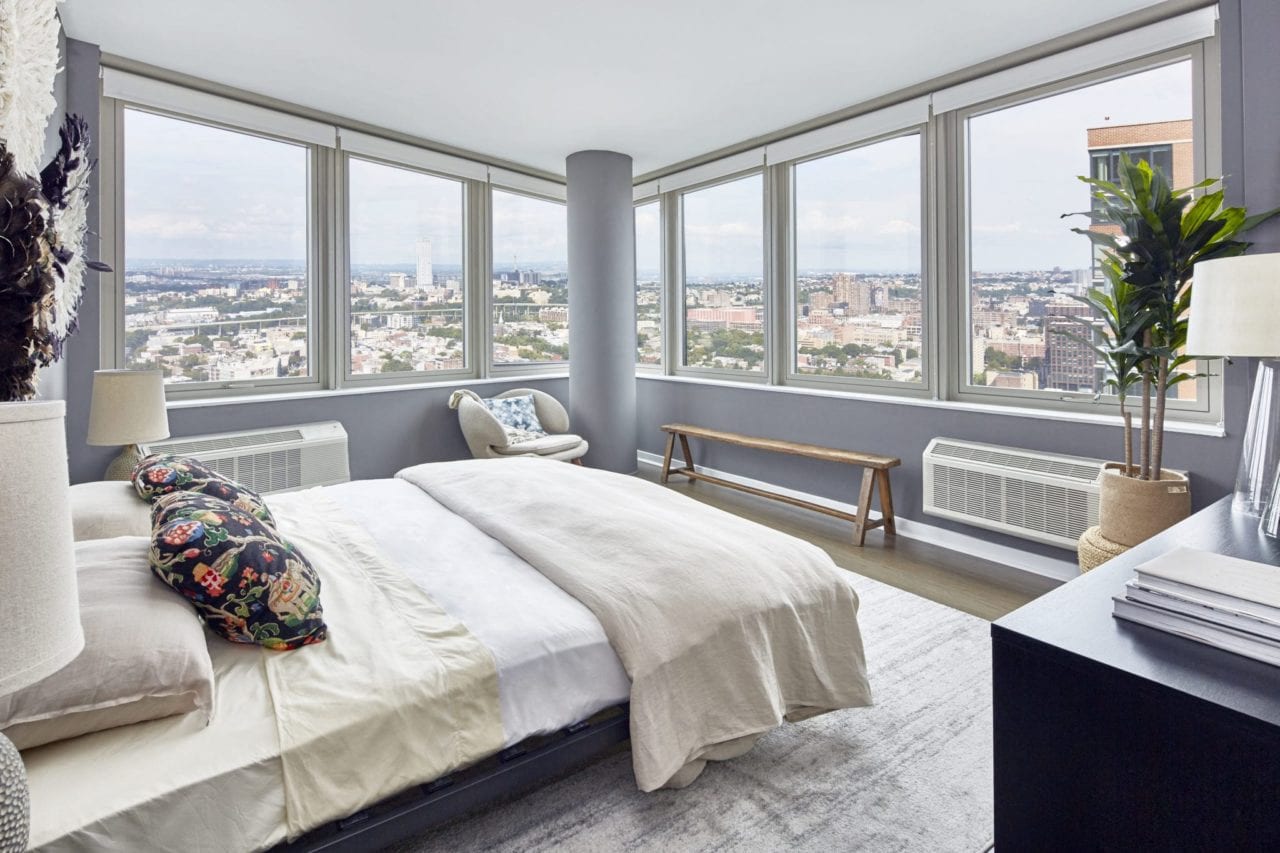 a bedroom with a bed and a view of the city