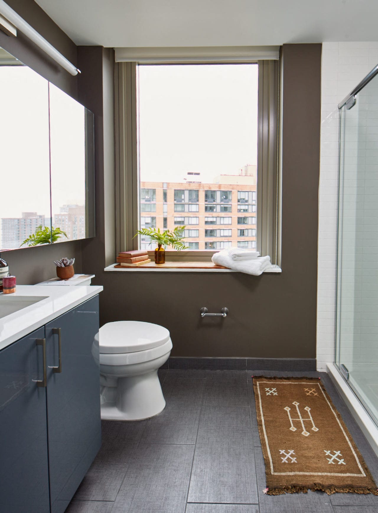 a bathroom with a toilet and a window and a sink