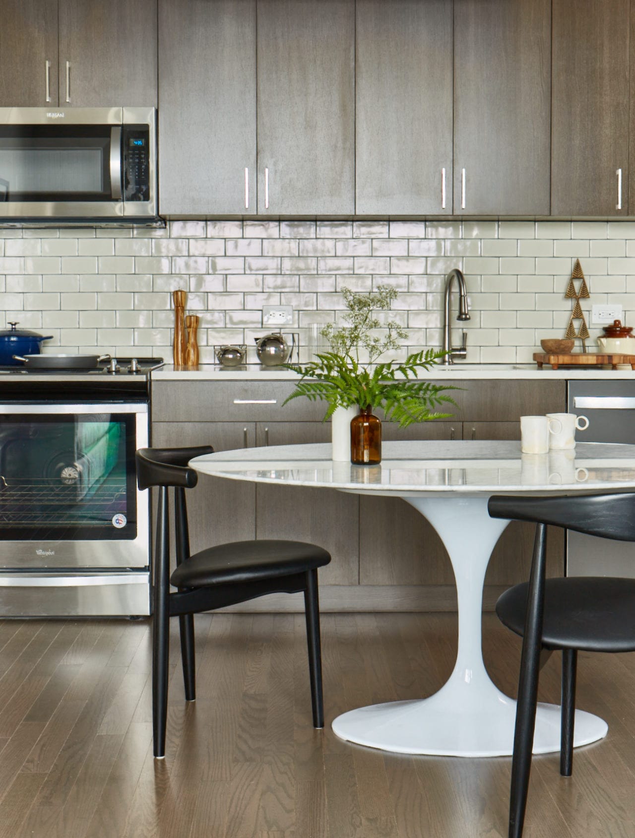 a kitchen with a white table and black chairs