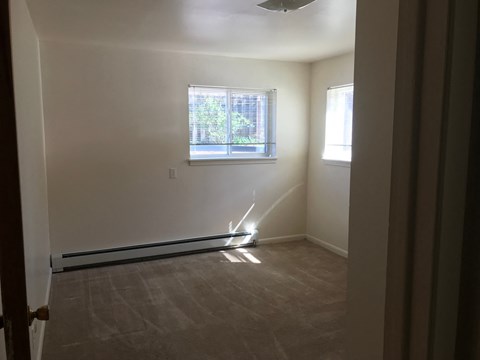A room with a window and a fan.