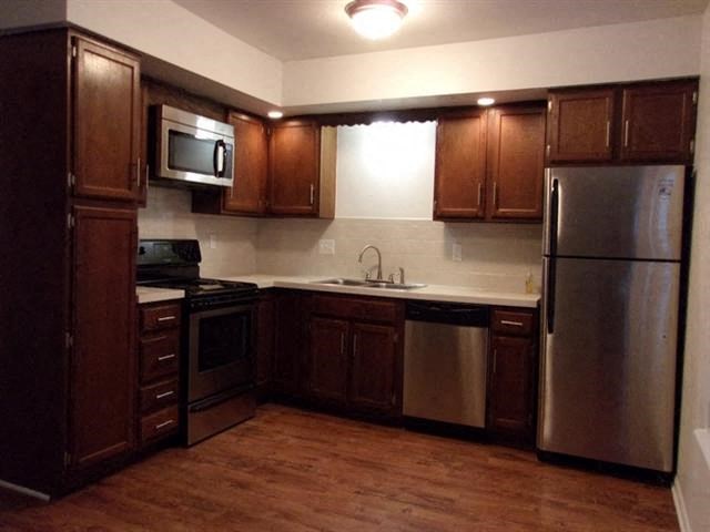 a kitchen with stainless steel appliances and wooden cabinets