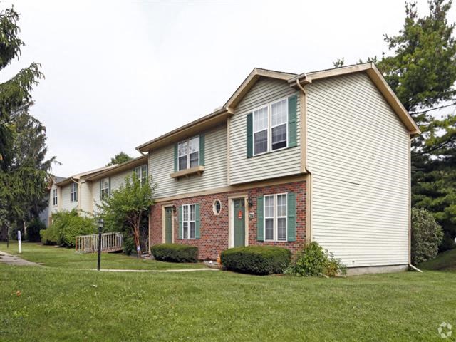 a white house with green shutters and a lawn