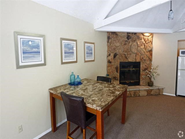 a dining room with a table and a stone fireplace