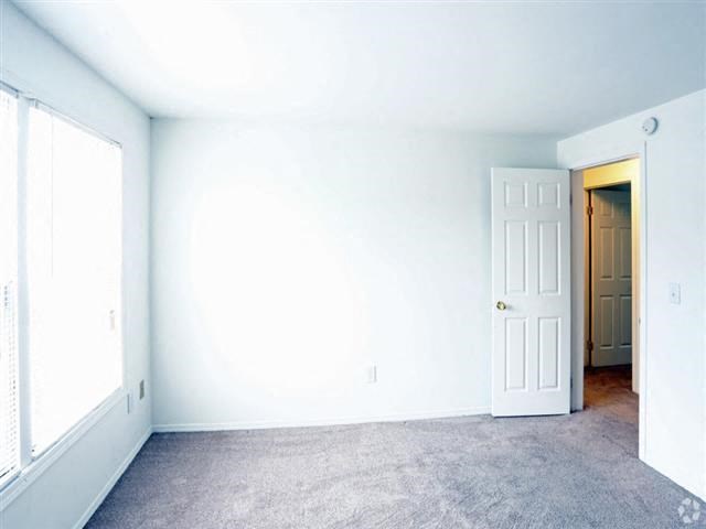 an empty room with a door and a white wall