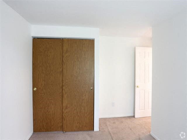 an empty room with a closet and a door