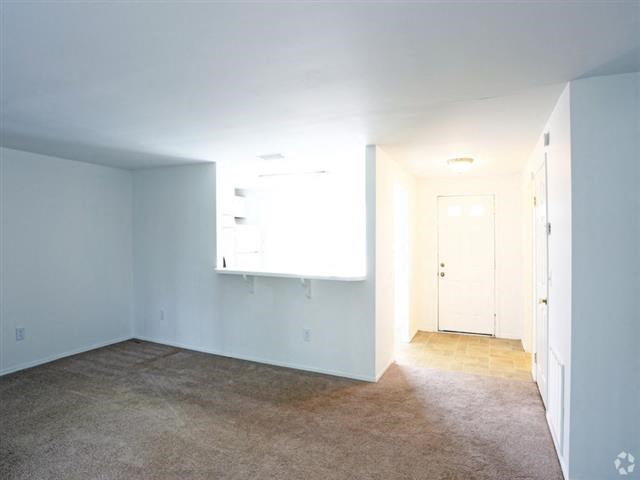 an empty room with white walls and a white door