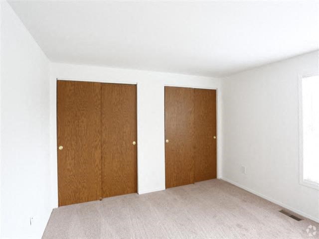 an empty room with two wooden doors in the wall