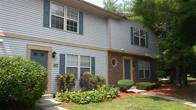 a white house with blue doors and a lawn