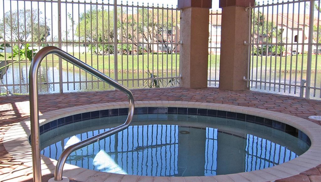 a swimming pool with a wrought iron fence around it