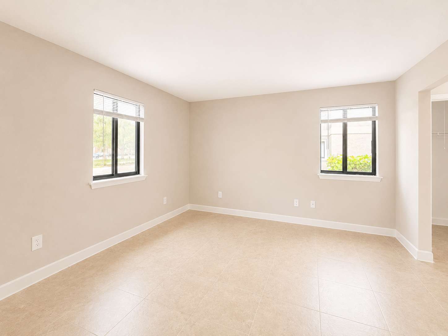 A room with two windows and tiled flooring.
