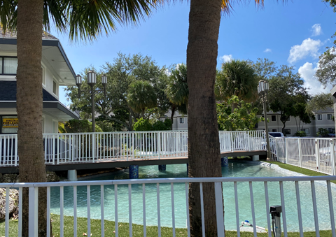 a bridge over a lagoon in front of a house