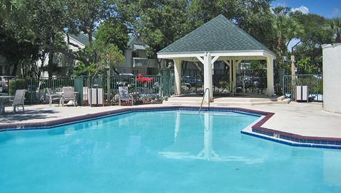 a swimming pool with a gazebo next to a resort pool