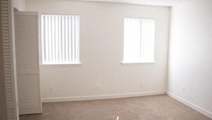 an empty room with two windows and a closet