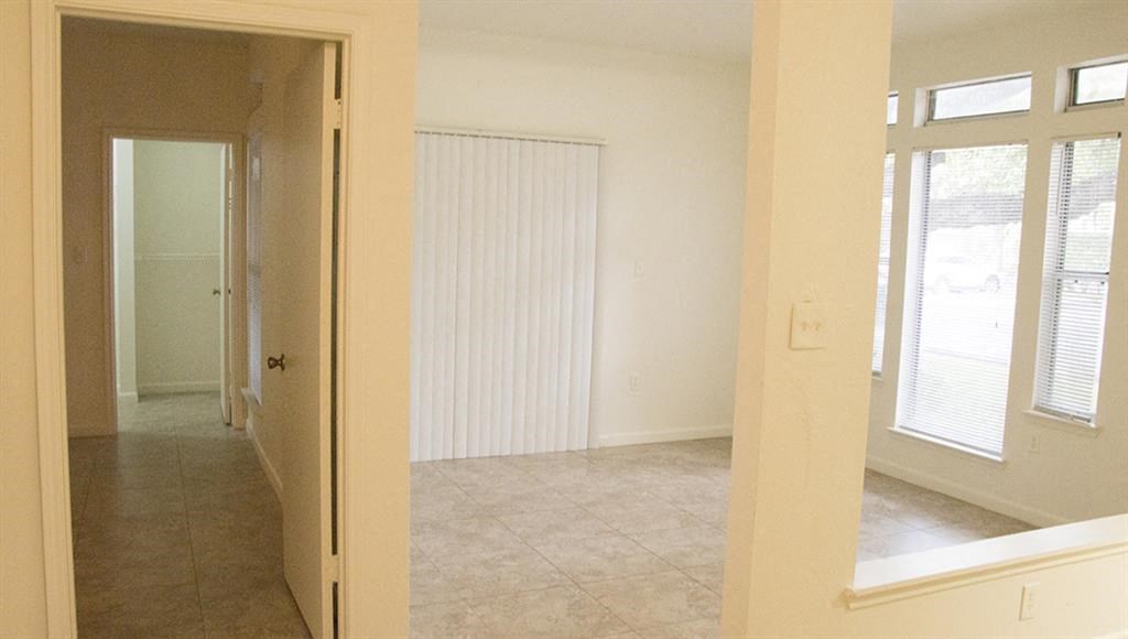 an empty living room with a door to a bedroom