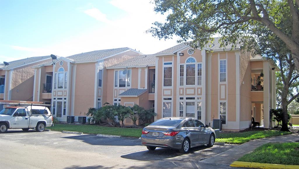 a row of houses with cars parked in front of them