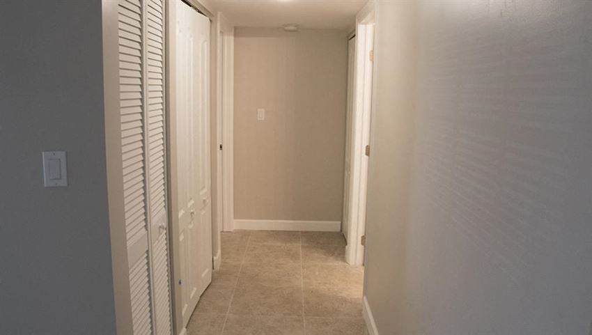 a hallway with a closet and a door to a bathroom