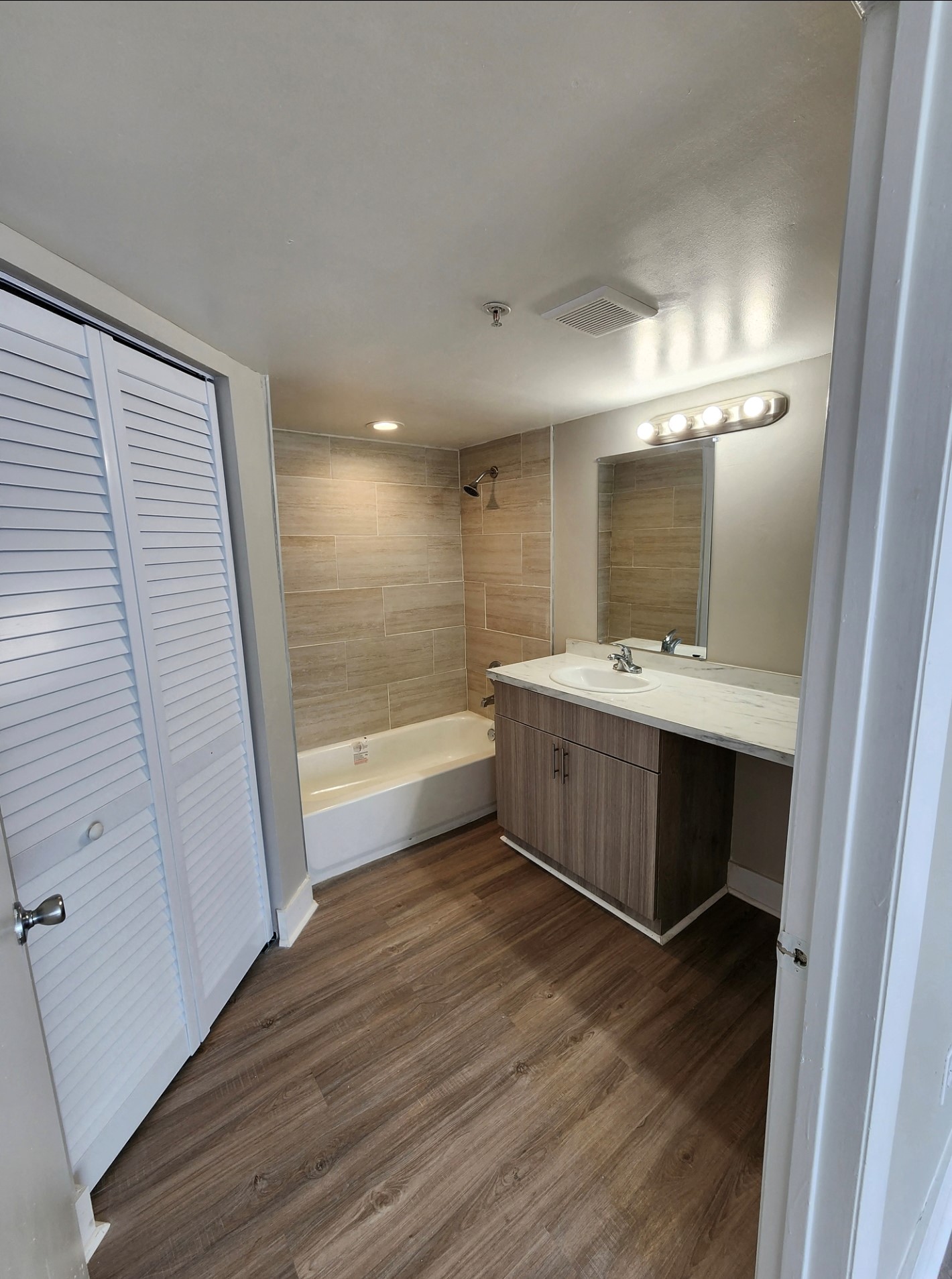 A bathroom with a white vanity and a white door.