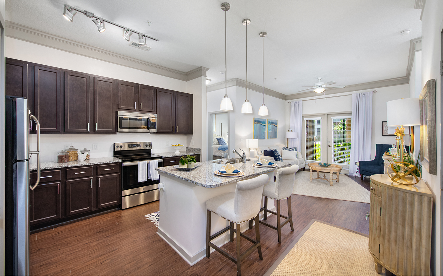 an open kitchen and living room with a large island with chairs and a counter