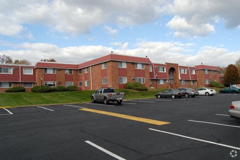 an apartment building with cars parked in a parking lot
