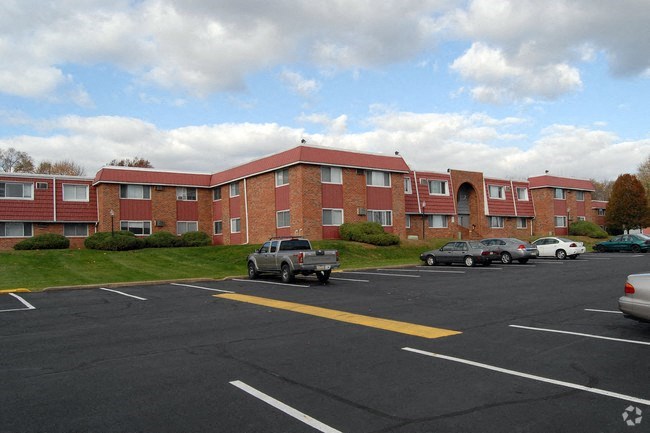 an apartment building with cars parked in a parking lot