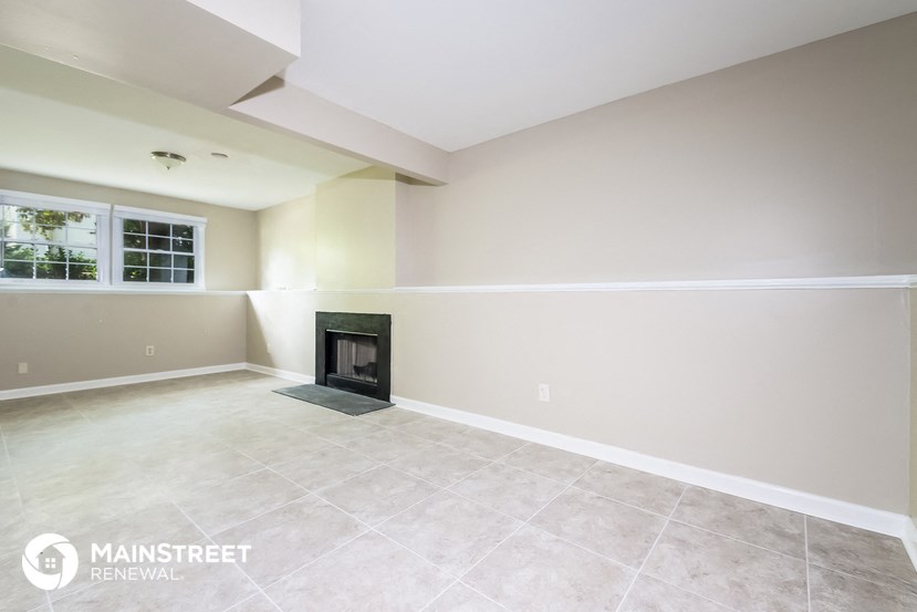 the living room has a fireplace and tile flooring