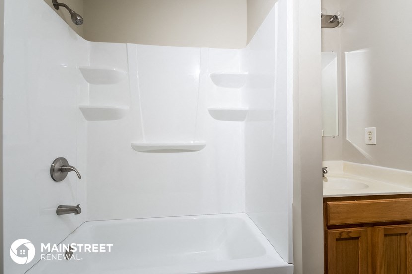 a white bathroom with a tub and a sink