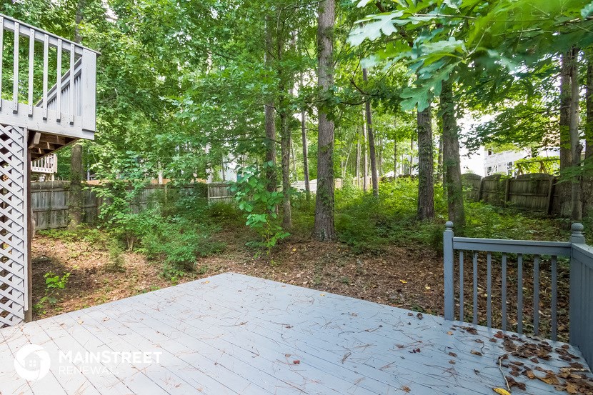 a deck with a view of the woods and a pond