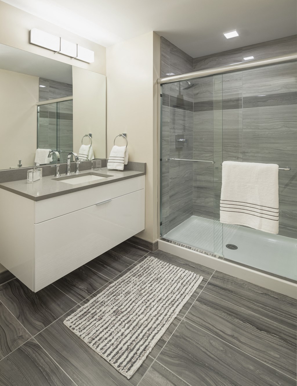 a bathroom with a shower and a sink and a mirror