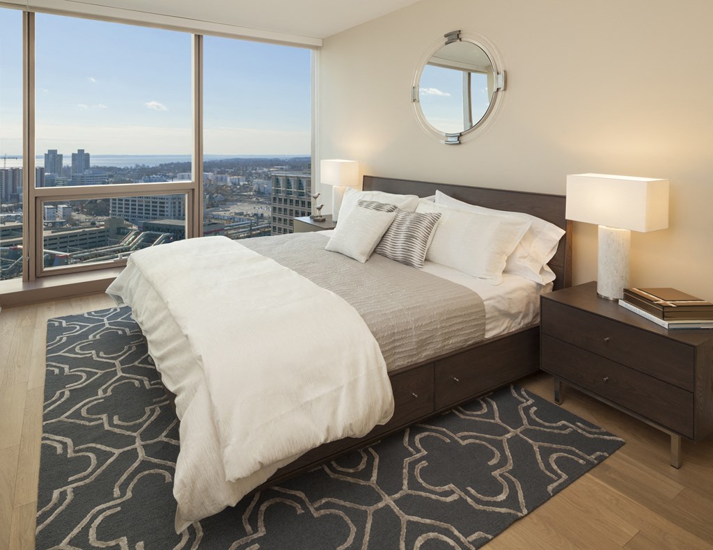 a bedroom with a bed and a view of the city
