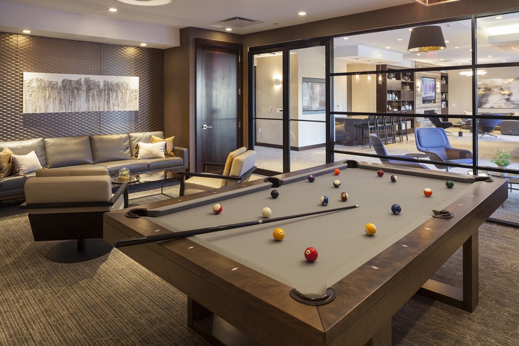 a billiards room with a pool table and couches