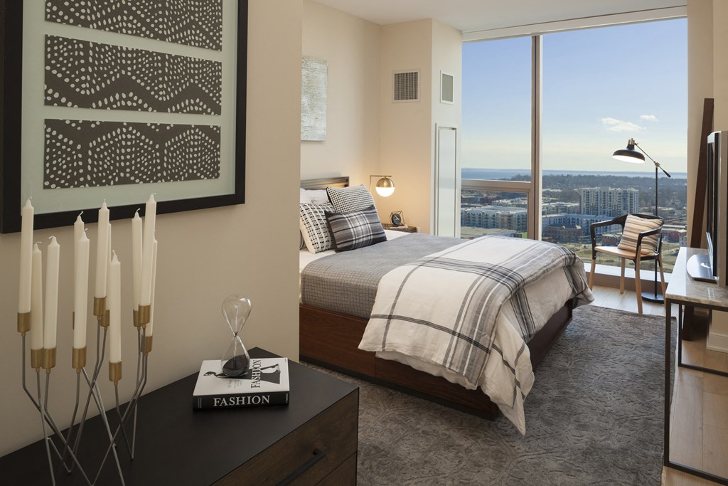 a bedroom with a bed and a view of the city