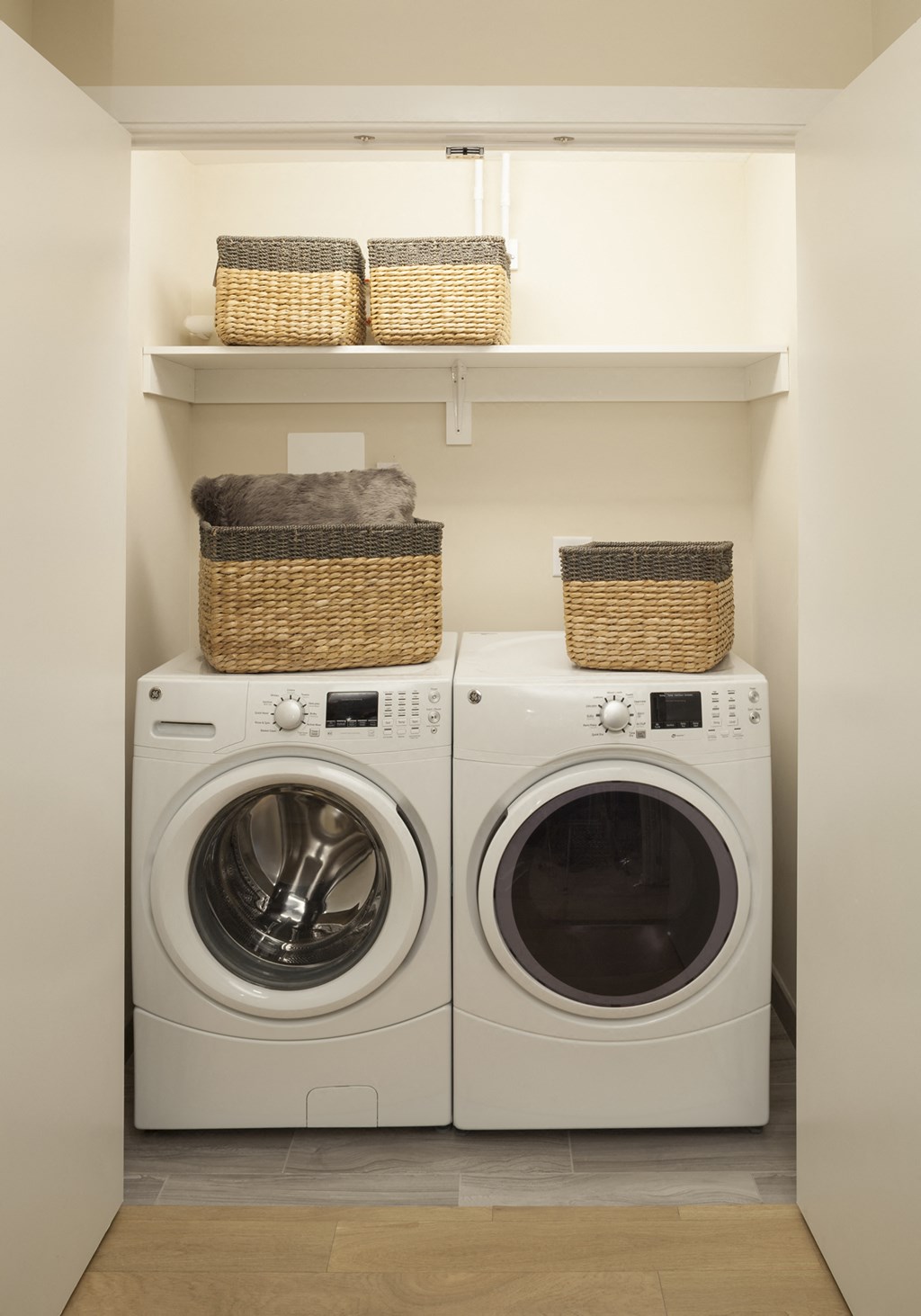 a washer and dryer in a laundry room with baskets on top