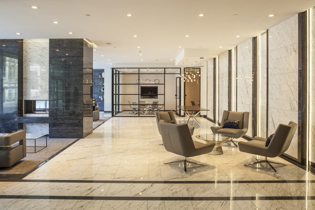 a lobby with chairs and a table and a fireplace