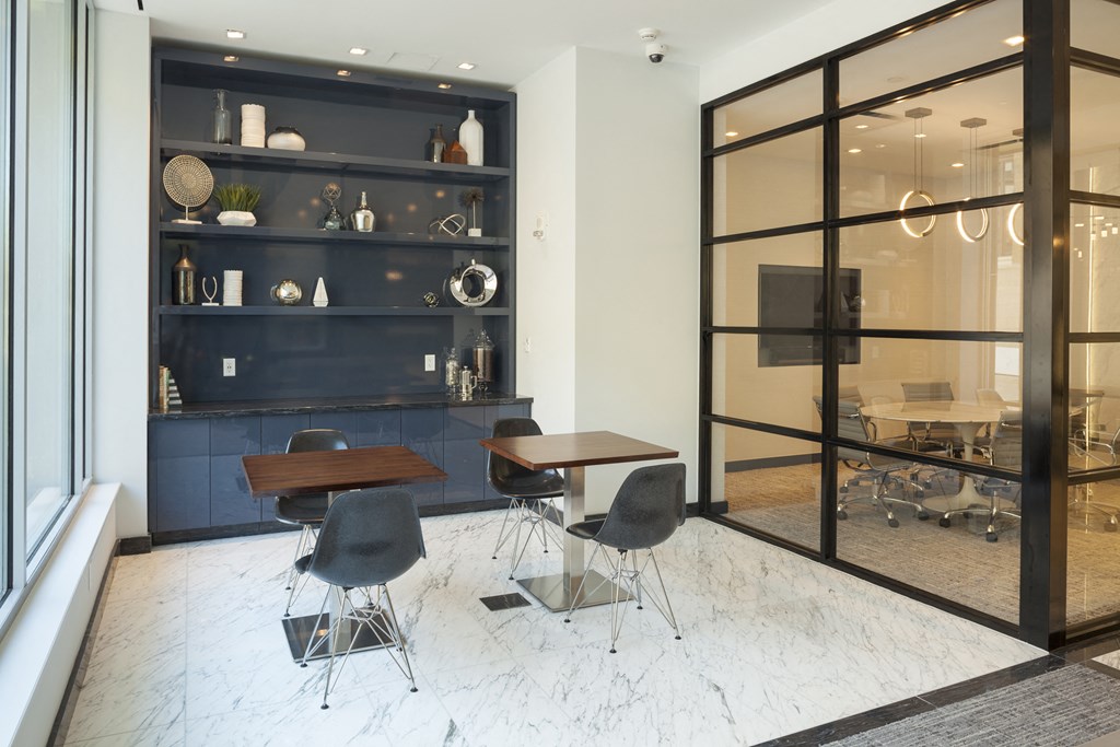 a meeting room with tables and chairs in front of a large glass window